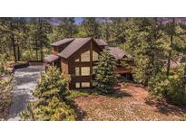 Stunning wooded home featuring expansive windows and a welcoming deck, perfect for nature lovers at 533 Tenderfoot Dr, Larkspur, CO 80118
