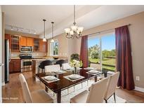 Bright dining area features hardwood floors, elegant chandelier, and sliding glass doors to the backyard at 12921 Grant Cir # B, Thornton, CO 80241