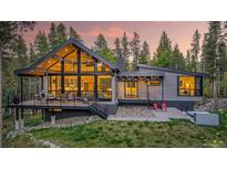 Modern mountain home with large windows and a deck overlooking a serene wooded setting at 55 Blue Flag Dr, Breckenridge, CO 80424