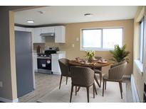 Bright kitchen and dining area with stainless steel appliances and a dining table set for four at 875 S Quebec St # 25, Denver, CO 80247