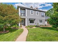 Charming gray two-story home with a manicured lawn and inviting walkway at 1100 S Garfield St, Denver, CO 80210