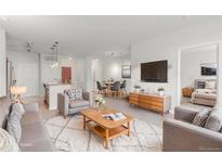 Bright living room featuring a cozy seating area and views of the kitchen and dining space at 13456 Via Varra # 224, Broomfield, CO 80020