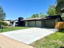 Charming single-story home featuring a wide driveway and covered parking, with green lawn and a minimalist aesthetic at 290 Beryl Way, Broomfield, CO 80020