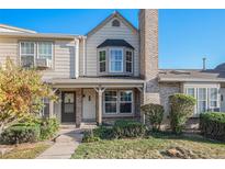 Inviting exterior of a charming townhome, featuring a brick facade and well-maintained landscaping at 9674 W Chatfield Ave # E, Littleton, CO 80128