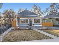 Charming home featuring many windows, tidy landscaping, and a walkway to the front door at 722 Kimbark St, Longmont, CO 80501