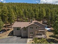 Beautiful two-story home with a large deck, three-car garage, and mature landscaping at 8724 Armadillo Trl, Evergreen, CO 80439