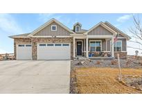 Two-story house with gray siding, stone accents, and a two-car garage at 15740 Spruce St, Thornton, CO 80602