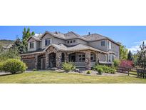 Charming two-story home with a stone facade, covered porch, landscaped yard, and attached two-car garage at 19096 W 53Rd Pl, Golden, CO 80403