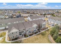 View of well-maintained townhomes with stone accents, landscaping, and a glimpse of a Gathering-friendly neighborhood at 12710 Jasmine St # C, Thornton, CO 80602