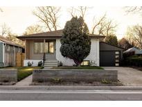 Charming ranch-style home features a brick exterior, a modern garage door, and a well-kept front yard at 4631 Zuni St, Denver, CO 80211