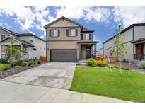 Charming two-story home featuring a well-manicured lawn, complemented by an attached two-car garage and a welcoming front porch at 933 Canal West Dr, Brighton, CO 80603