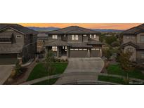 Beautiful two-story home with a three car garage, landscaped front yard and a stunning sunset at 16371 Jones Mountain Way, Broomfield, CO 80023