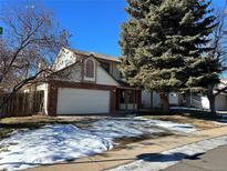 Brick two-story house with attached garage and snow-covered driveway at 17548 E Wesley Pl, Aurora, CO 80013