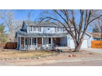 Charming two-story home featuring a welcoming front porch, a well-maintained lawn, and mature trees at 1109 E 7Th Avenue Cir, Broomfield, CO 80020