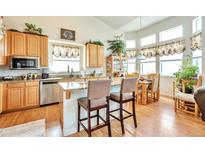 Bright kitchen with island, stainless steel appliances, and natural light from large windows at 1851 Ute Creek Dr, Longmont, CO 80504