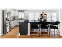 Modern kitchen features an eat-in island with seating and stainless steel appliances at 6567 S Elizabeth Way, Centennial, CO 80121