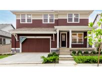 Two-story home with a front-entry garage, covered porch, and nicely landscaped front yard at 1826 Hickory Ave, Erie, CO 80516
