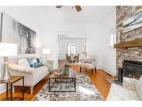 Bright living room boasts a stone fireplace, hardwood floors, and neutral decor for a cozy feel at 1723 E 16Th Ave, Denver, CO 80218