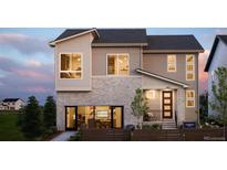 Modern two-story home showcasing a stone facade, large windows and manicured landscaping at 6304 Las Conchas Pt, Parker, CO 80134