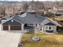 Charming single-story home with manicured front yard, garage, and inviting entrance at 8393 S Wadsworth Ct, Littleton, CO 80128