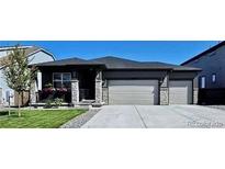 Charming home with stone accents, well-kept lawn, and a three-car garage for ample parking at 13432 Broad Wing Dr, Parker, CO 80134