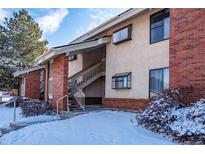 Brick and siding apartment building showcasing stairs to the upper units, surrounded by snow-covered landscaping at 595 Manhattan Dr # 203, Boulder, CO 80303