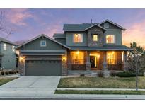 Charming two-story home with a stone facade, covered porch, and well-maintained lawn at 13673 Osage St, Broomfield, CO 80023