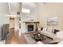 Bright living room features a stone fireplace, hardwood floors, neutral colors, and plenty of natural light at 8635 Clay St # 417, Westminster, CO 80031