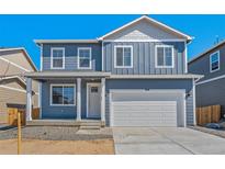 Charming two-story home with a blue exterior, a white garage door, and a well-manicured front lawn at 6531 14Th St, Frederick, CO 80530