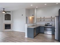 Modern kitchen features stainless steel appliances, open shelving, and ample counter space at 10035 E Carolina Pl # 201, Aurora, CO 80247