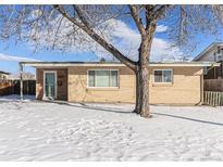 Ranch style home with brick exterior, front door, and snowy yard at 7674 Stuart St, Westminster, CO 80030