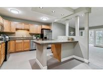 Updated kitchen featuring stainless steel appliances, stone countertops, and a functional breakfast bar at 610 S Clinton St # 3D, Denver, CO 80247