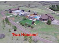 Sprawling property featuring two homes, a pool, playground, and RV parking, surrounded by open land at 1063 Clarke Ct, Castle Rock, CO 80109