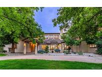 Beautiful two-story home featuring a stone facade, manicured landscaping, and a tranquil setting surrounded by mature trees at 9678 E Powers Dr, Greenwood Village, CO 80111