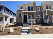 Inviting two-story home featuring stone accents, neutral tones, and well-manicured landscaping at 6638 N Nepal Ct, Aurora, CO 80019