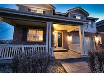 Charming brick home showcasing a welcoming front porch with classic white columns and manicured landscaping at 23426 E Ottawa Dr, Aurora, CO 80016