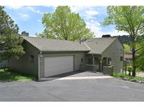 Charming home featuring a two-car garage, well-maintained lawn, and a welcoming front porch at 23846 Genesee Village Rd, Golden, CO 80401