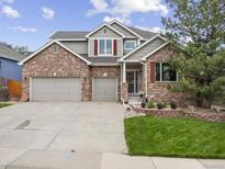 Charming two-story brick home with a three car garage and lush front yard at 6432 S Robb Ct, Littleton, CO 80127