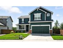 Two-story home with a two-car garage, lush lawn, and well-maintained landscaping at 3543 Foxridge Trl, Highlands Ranch, CO 80126