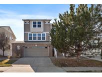 Charming three-story home with a brick and siding facade and a two-car garage at 4787 Dunkirk St, Denver, CO 80249