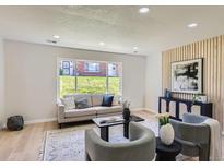 Cozy living room with modern decor, wood accent wall, and ample natural light at 9263 E Nassau Ave, Denver, CO 80237