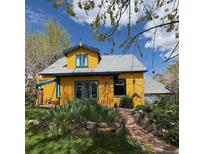 Charming yellow home with unique architectural details and lush front yard landscaping at 2320 22Nd St, Boulder, CO 80304