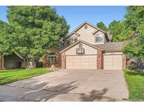 Charming home with a two-car garage, mature trees, and a well-maintained lawn at 7420 S Houstoun Waring Cir, Littleton, CO 80120