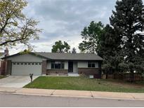 Charming single-story home with an attached garage and a well-maintained front lawn at 4115 S Vincennes Ct, Denver, CO 80237