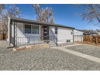 Charming home featuring white siding, stone accents, updated windows and inviting front porch with metal railing at 4611 W 2Nd Ave, Denver, CO 80219