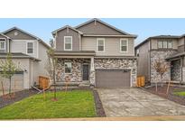Charming two-story home showcasing a modern design with stone accents and a well-manicured lawn at 553 Homestead Ave, Brighton, CO 80601