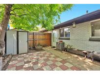 Cozy backyard patio featuring red and white checkered pavers, a storage shed, and a charming wooden bench at 2955 N Gilpin St, Denver, CO 80205