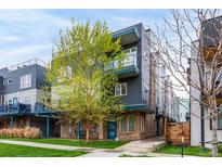 Modern townhouse featuring a blue accented exterior, complemented by fresh spring foliage and a well-manicured lawn at 1941 Hooker St, Denver, CO 80204