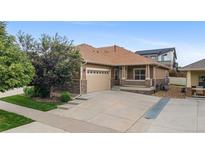 Charming single-Gathering home featuring a two-car garage, stone accents, and a covered porch at 4400 S Ensenada St, Aurora, CO 80015