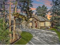 Two-story home with stone accents, three-car garage, and landscaped yard at 5224 Knobcone Dr, Castle Rock, CO 80108